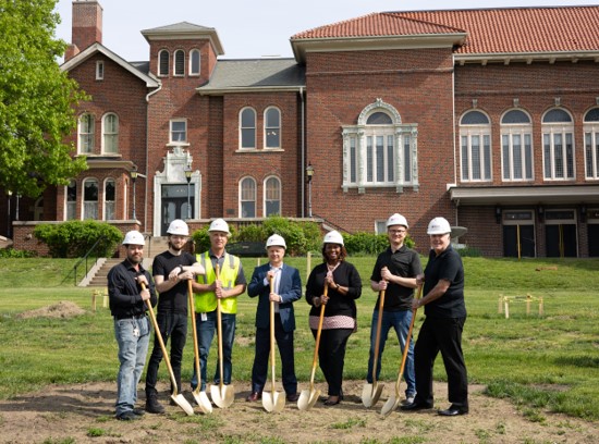 seven people standing with golden shovels in front of hoyt sherman place