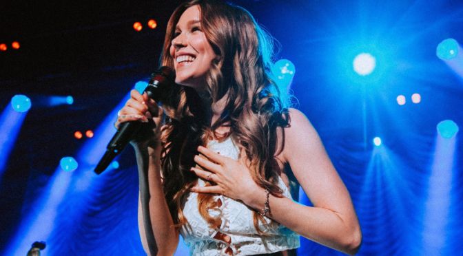 joss stone holding microphone and smiling on stage